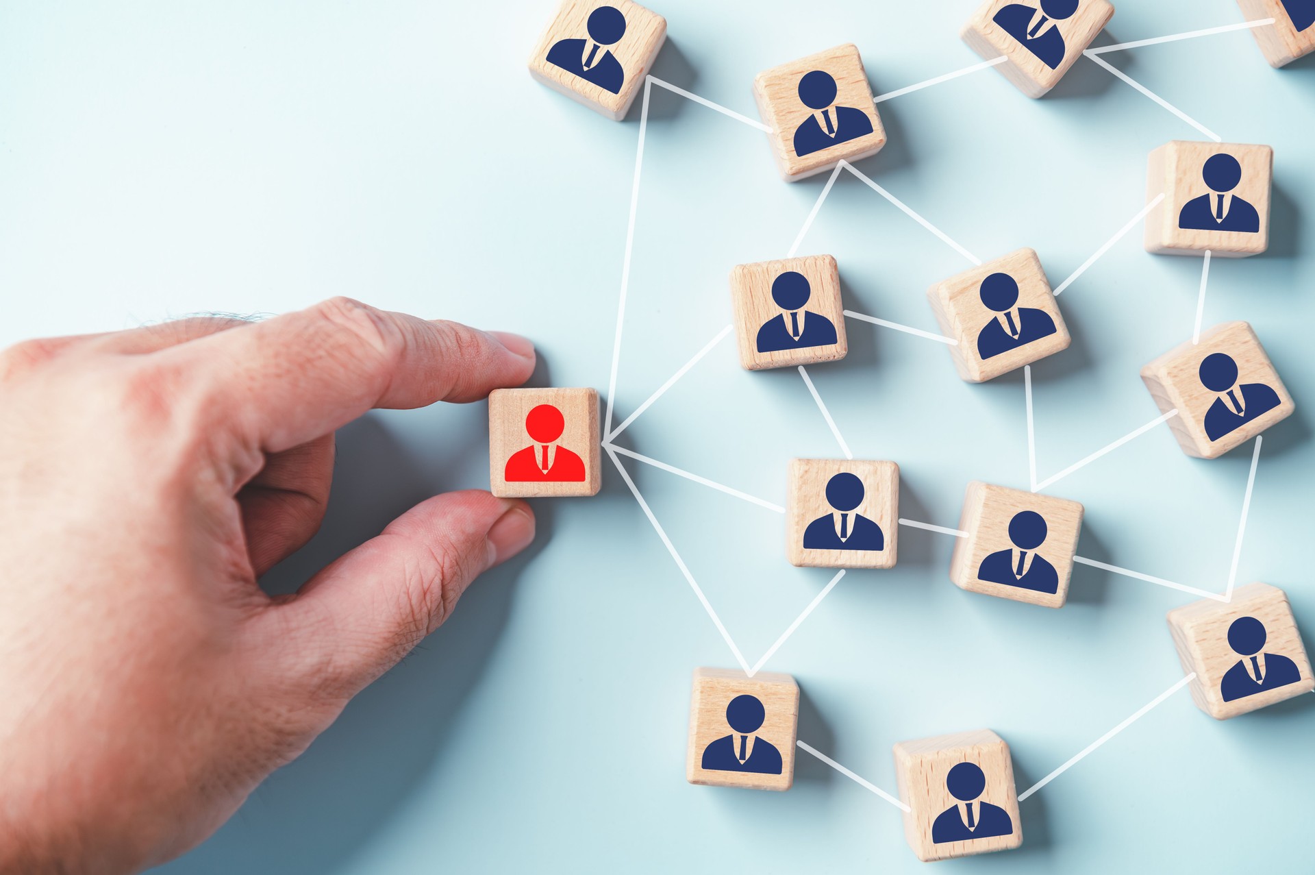 Hand placing red leader staff businessman icon wooden block. Business job hiring recruitment selection. Career opportunity human resource management leadership employees team. Partnership management.